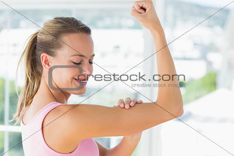 Young woman flexing muscles in the gym