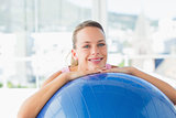 Smiling fit woman with exercise ball at gym
