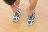 sporty man stretching hands to legs in fitness studio