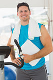 Portrait of a smiling trainer with clipboard in gym