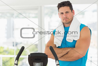 Serious young man working out at spinning class