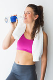 Young woman with towel drinking water