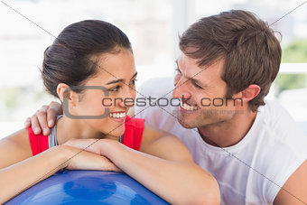 Closeup portrait of a smiling fit couple with exercise ball