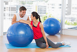 Smiling fit young couple with exercise ball at gym