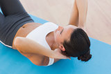 Determined woman doing abdominal crunches on exercise mat