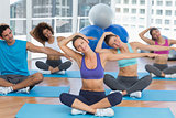 People with trainer doing pilate exercises