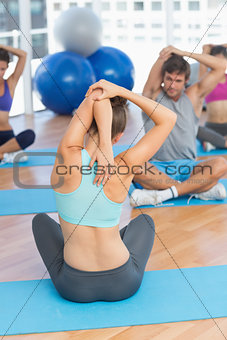 People with trainer stretching hands behind backs