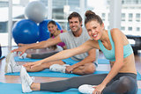 Smiling people doing stretching exercises