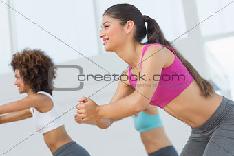 Cheerful fitness class doing pilates exercise