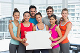 Fit smiling people holding blank board