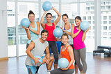 Fit young people with balls in exercise room
