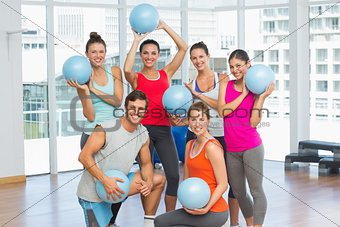 Fit young people with balls in exercise room