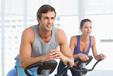Smiling couple working out at spinning class
