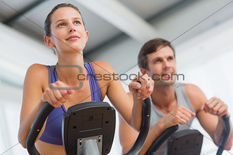 Smiling couple working out at spinning class