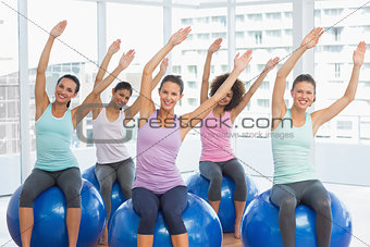 Smiling young people sitting on exercise balls