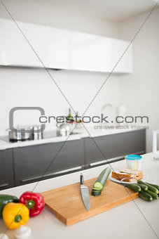 Vegetables with knife and chopping board on kitchen counter