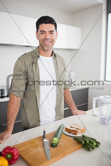 Man with vegetables and chopping board in kitchen