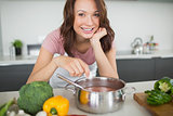 Portrait of smiling woman preparing food in kitchen