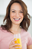 Portrait of a smiling woman holding orange juice