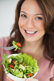 Closeup of smiling woman with bowl of salad