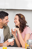 Happy loving couple with coffee cup in kitchen