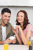 Happy couple with coffee cup in kitchen