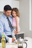 Well dressed father carrying his daughter while preparing food