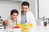 Young son with father having breakfast in kitchen