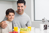 Portrait of happy son with father having breakfast