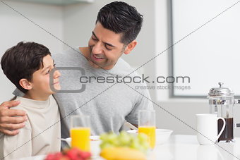 Young son with father having breakfast