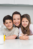Closeup of a smiling mother with kids in kitchen