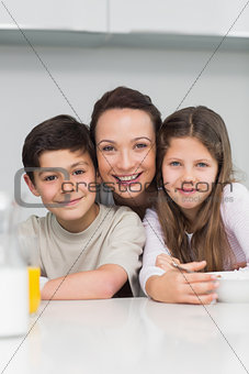 Closeup of a smiling mother with kids in kitchen