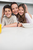 Portrait of a smiling mother with kids in kitchen