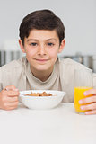 Smiling young boy enjoying breakfast in kitchen