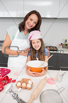 Young girl and mother preparing cookies in kitchen