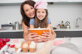 Portrait of a girl and mother preparing cookies in kitchen