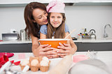 Girl and mother preparing cookies in kitchen
