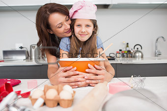 Girl and mother preparing cookies in kitchen