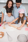 Family of four preparing cookies in the kitchen