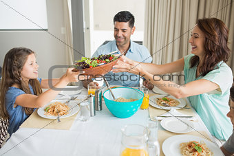 Happy family of three sitting at dining table