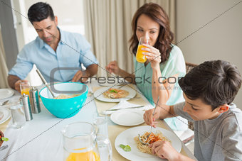 Family of three sitting at dining table