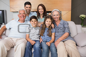 Portrait of smiling extended family on sofa in living room