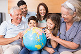 Extended family sitting on sofa with globe in the living room