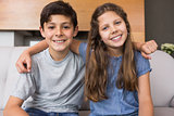 Portrait of smiling little siblings in living room