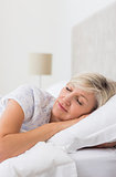 Mature woman sleeping with eyes closed in bed