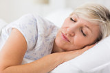 Woman sleeping with eyes closed in bed