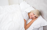 Pretty mature woman resting in bed