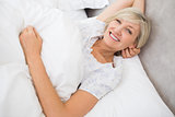 Pretty mature woman resting in bed