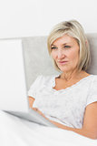Mature woman using laptop in bed