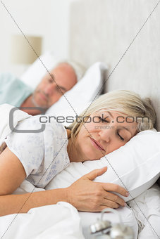 Mature couple sleeping with eyes closed in the bed
